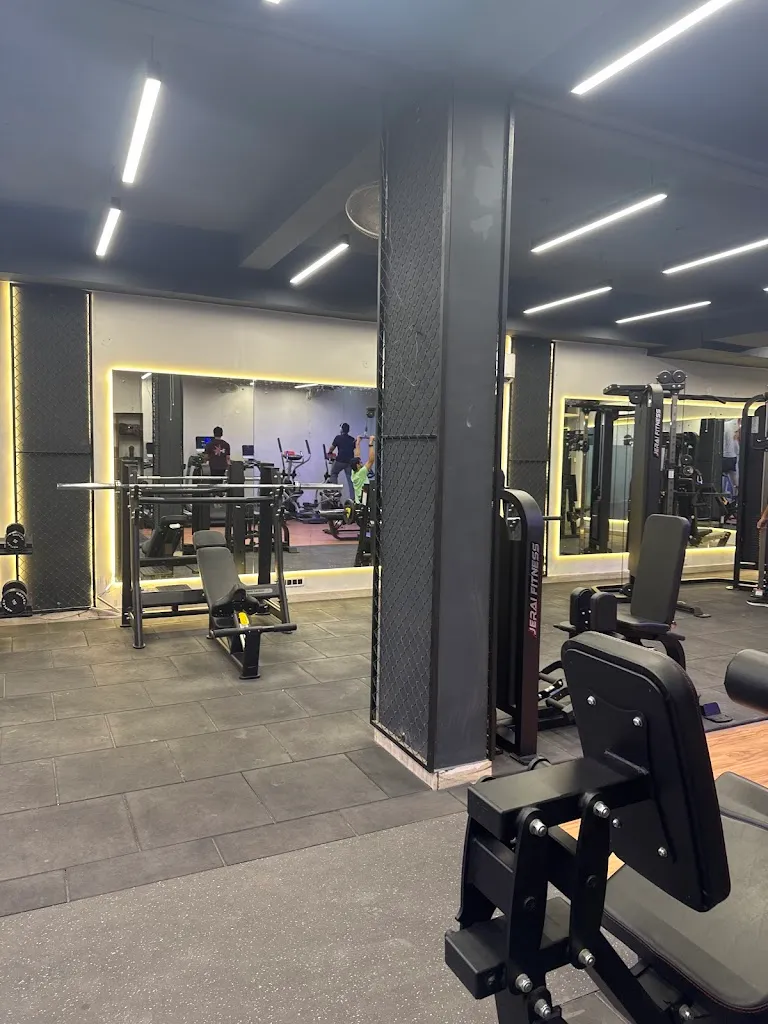 A machine circuit at Evolve Gym, including a leg extension machine, a cable station and a rack of free weights.