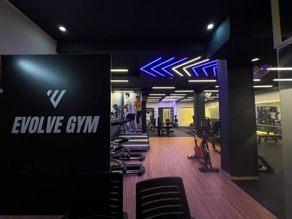 The Evolve Gym training floor, with a row of treadmills, cardio machines and a mirrored wall beneath a lit ceiling.